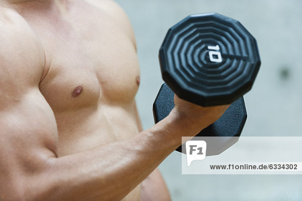 Man doing bicep curl with dumbbell  mid section