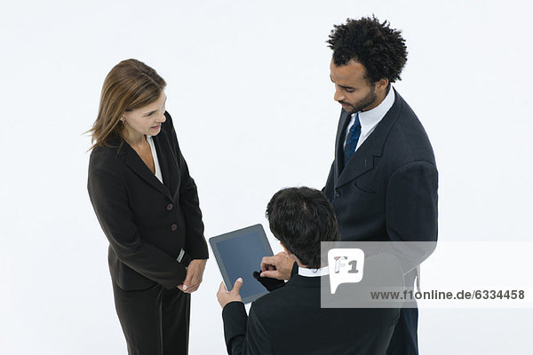 Geschäftspartner chatten  während der Kollege ein digitales Tablett benutzt