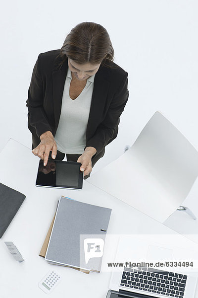 Geschäftsfrau am Schreibtisch mit digitalem Tablett