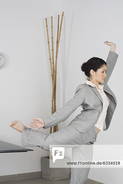 Junge Geschäftsfrau beim Yoga im Büro