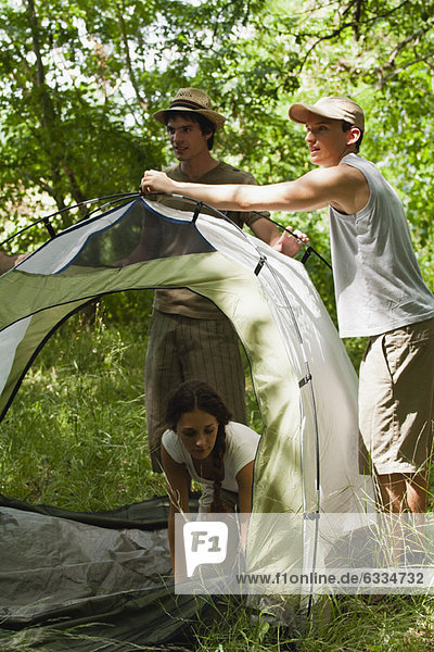 Young campers setting up tent in woods