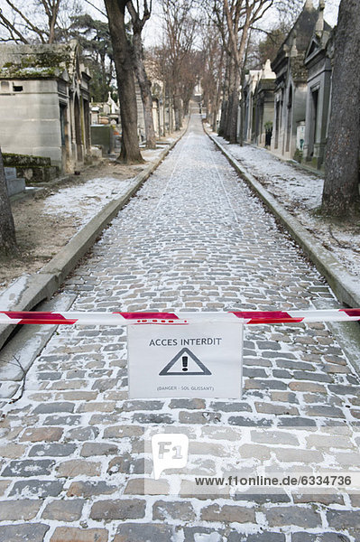 Sign warning pedestrians of slippery walkway in winter