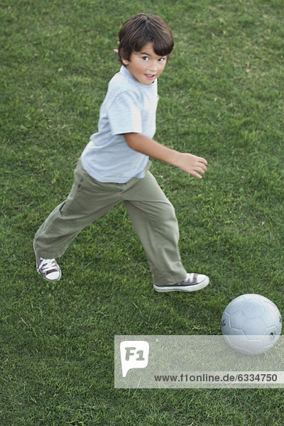 Junge spielt mit Fußball im Freien