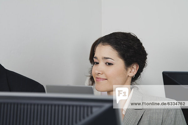 Young businesswoman looking at computer monitor