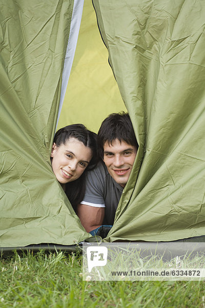 Junges Paar  das aus dem Zelt schaut.