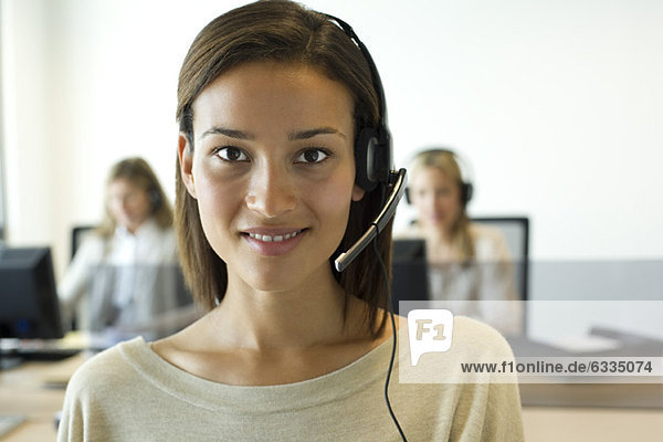 Woman using headset in office  portrait
