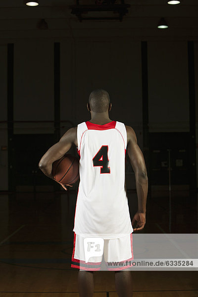 Basketball player holding basketball  rear view