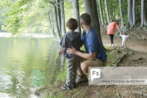 Vater und Sohn fischen im Wald  beide schauen weg