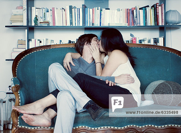 Couple kissing on sofa