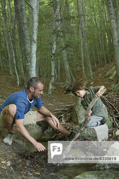 Vater und Sohn spielen im Wald
