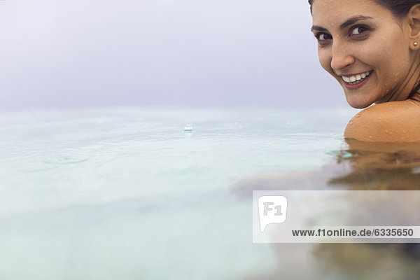 Woman in water  looking over shoulder at camera  portrait