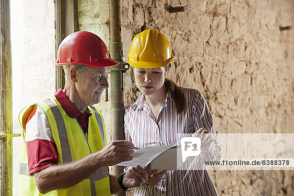 Bauarbeiter bei der Prüfung von Unterlagen