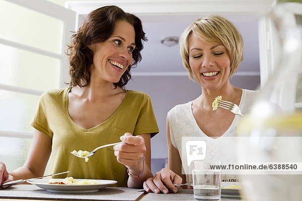 Lächelnde Frauen beim gemeinsamen Mittagessen
