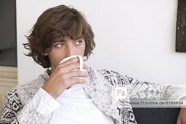 Teenage boy drinking cup of coffee