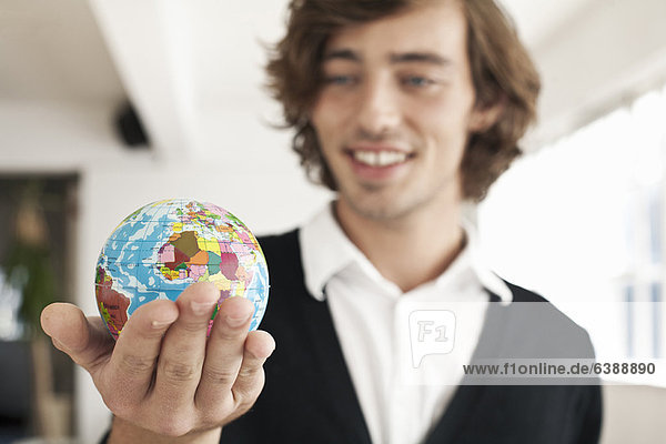 Teenager-Junge mit Miniatur-Globus