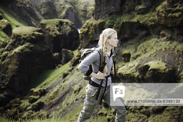 Hiker wearing backpack on mountainside