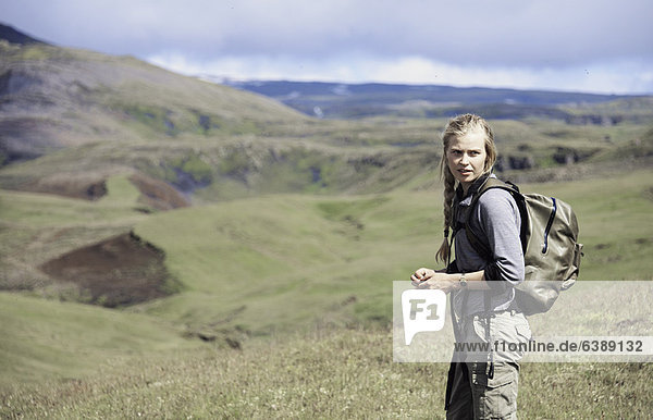 Hiker wearing backpack on hillside
