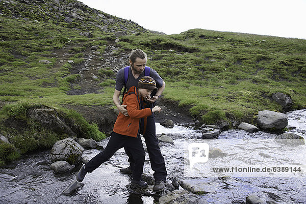 Father and daughter crossing stream