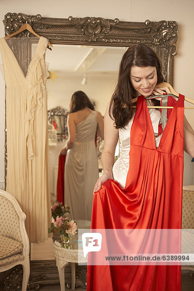 Frau untersucht Kleid im Geschäft