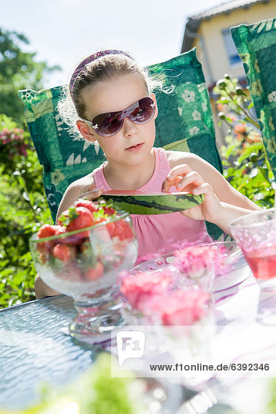 Girl eating watermelon in the garden