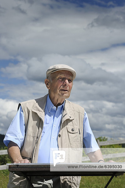 Ein alter Mann studiert eine Orientierungstafel im Gelände  Deutschland  Europa  ÖffentlicherGrund