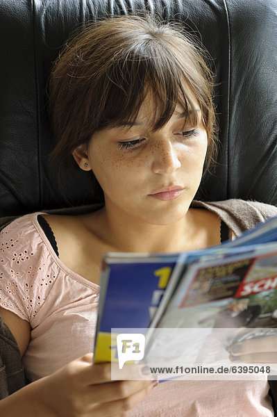 Eine junge Frau liest in einem Journal  Deutschland  Europa