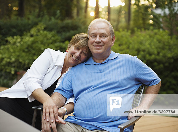 Caucasian couple sitting together and holding hands