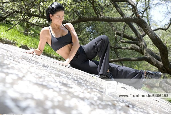 Junge Frau macht Fitnessübungen für die Oberschenkel