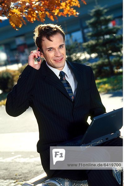 Businessman mit Laptop im Park