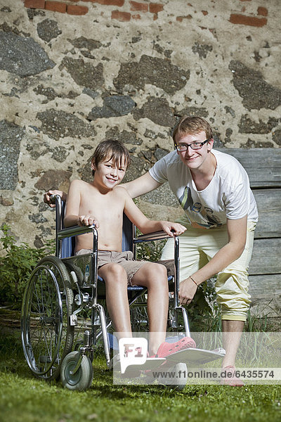 Junge im Rollstuhl mit Begleiter