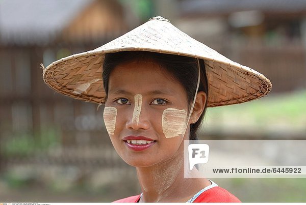 Junge Frau mit Thanaka-Paste auf Nase und Wangen *** Local Caption ***