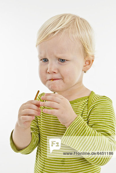 Ein Kleinkind isst eine Brezelstange.