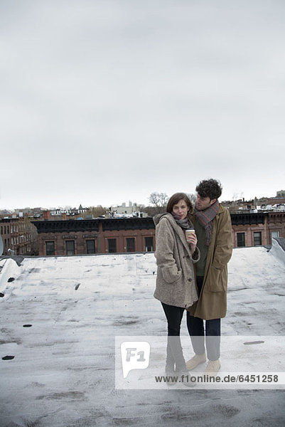 Ein junges Paar steht im Winter auf einem Dach  Brooklyn  New York