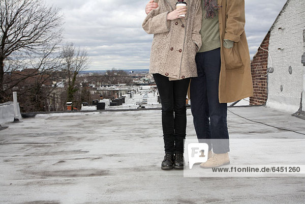 A young couple standing on a roof in winter  Brooklyn  New York
