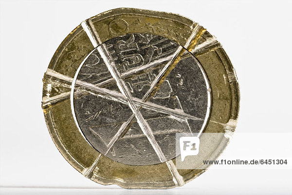 Eine Ein-Euro-Münze mit gekreuzten Dellen darin