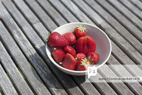 Eine Schale Erdbeeren auf einem Tisch im Freien