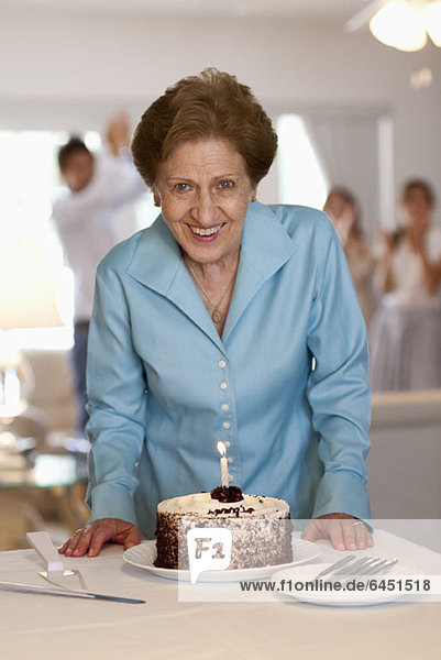 Eine ältere Frau mit einem Kuchen