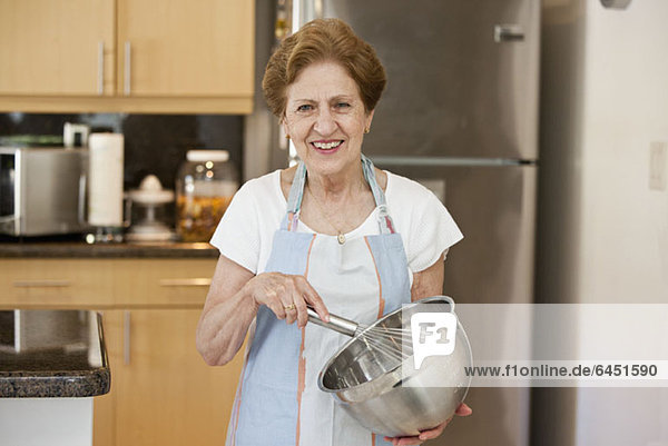 Eine ältere Frau mischt Zutaten in einer Schüssel