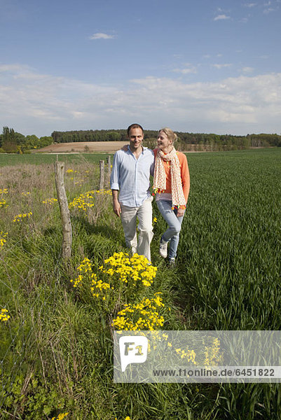 A couple walking side by side in a field