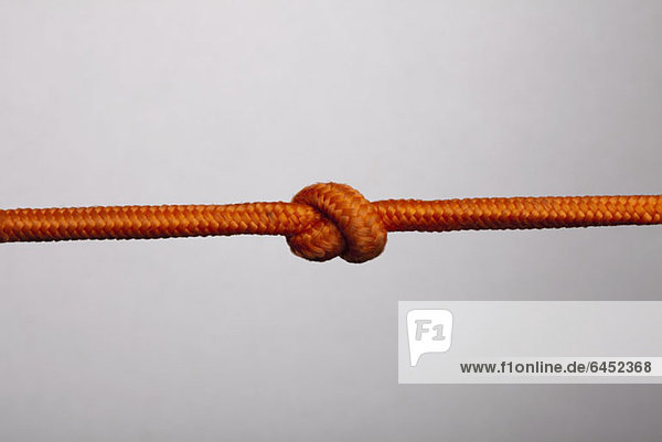 Ein orangefarbenes Seil mit einem Knoten darin