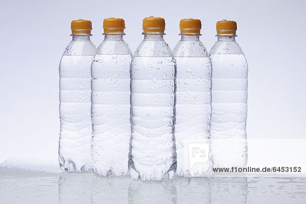 Eine Reihe von fünf Vollkunststoff-Wasserflaschen  die in einer Pyramide angeordnet sind.