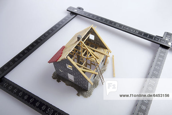 Ein teilweise gebautes Modell eines Hauses und eines Zollstockes