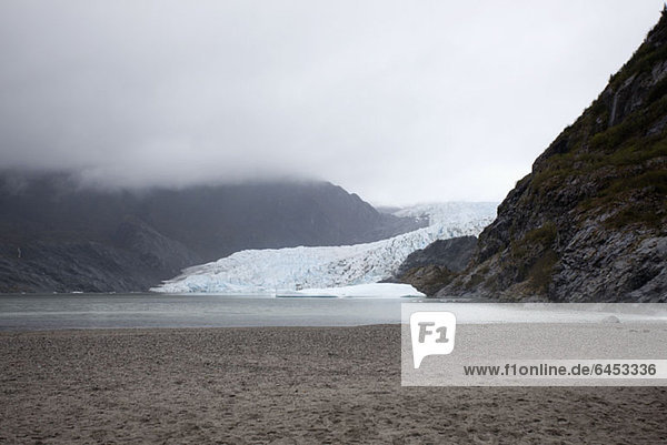 A distant person standing on a beach near Mendenhall Glacier  Alaska