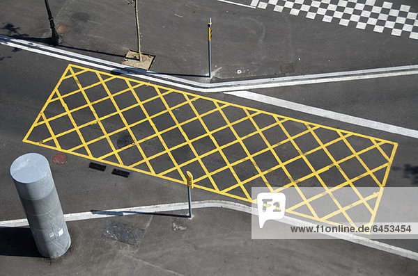 Gelbe Linien auf der Straße zur Markierung von'Halteverbot' in der Nähe einer roten Ampel/Kreuzung