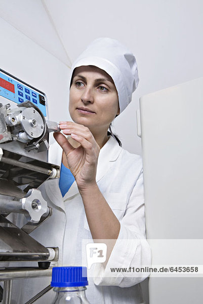 Ein Laborant stellt einen Knopf an einem medizinischen Diagnosegerät ein.