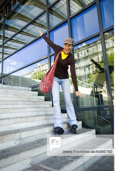Junge Frau mit Rollerskates auf einer Treppe