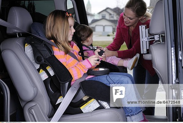 Mutter schnallt ihre Töchter im Auto an *** Local Caption ***