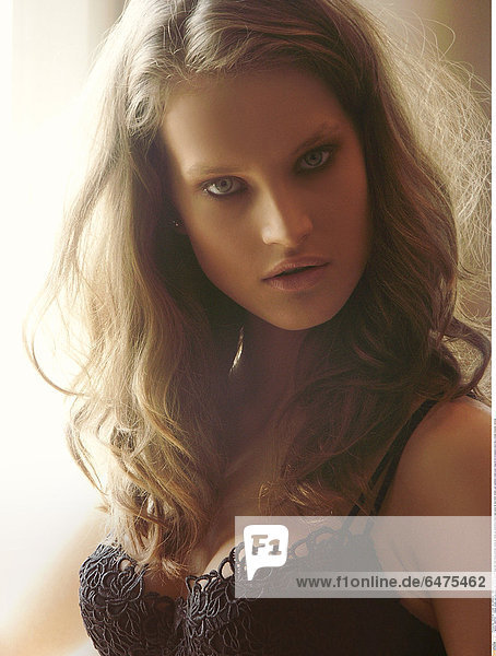 1224754 indoor studio woman young girl 20-25 blonde long hair lock locks portrait close up make up cosmetics black eye eyes lip lips think dream sad sadness underwear lingerie bra brassiere lace lacy breast breasts vertical