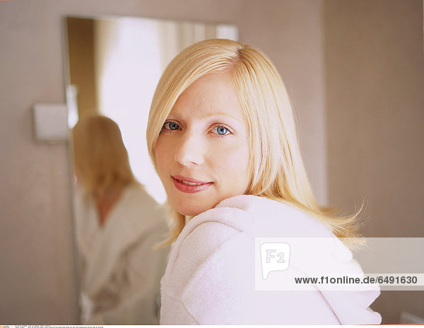 1234831 indoor flat bathroom people woman young 20-25 girl blonde smile smiling rest relax white dressing gown portrait close up horizontal