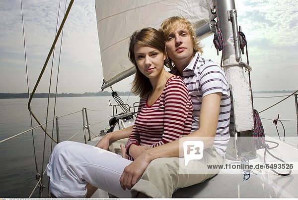 1237103 outdoor marina water lake evening summer people friend friends friendship young woman women girls man girl boy 20-25 brunette blouse blouses stripe stripes striped red white sailing boat sailing boat steer vacation holidays recreation sailing yachting smile smiling horizontal close up day